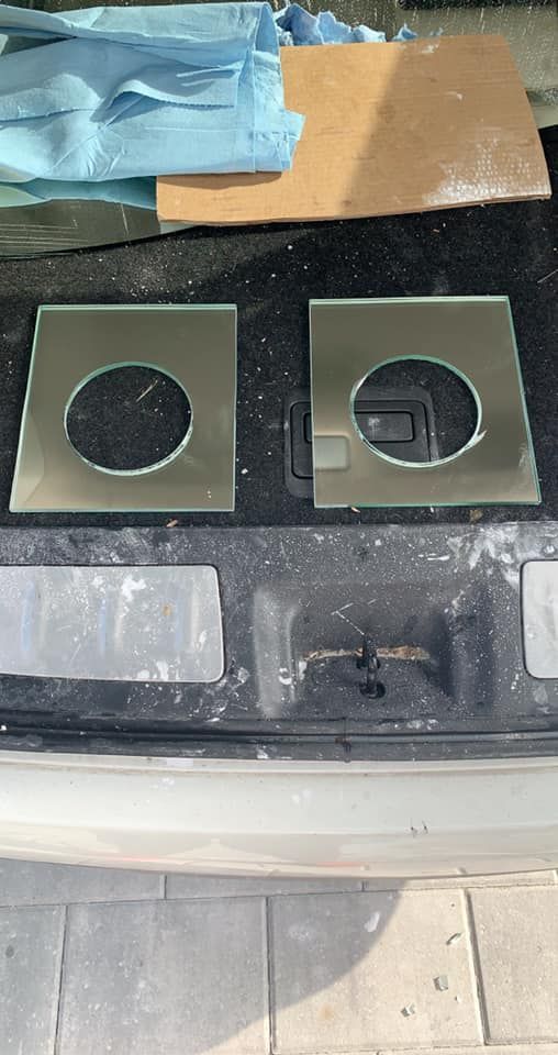 Two square glass panels with circular cutouts on a surface.