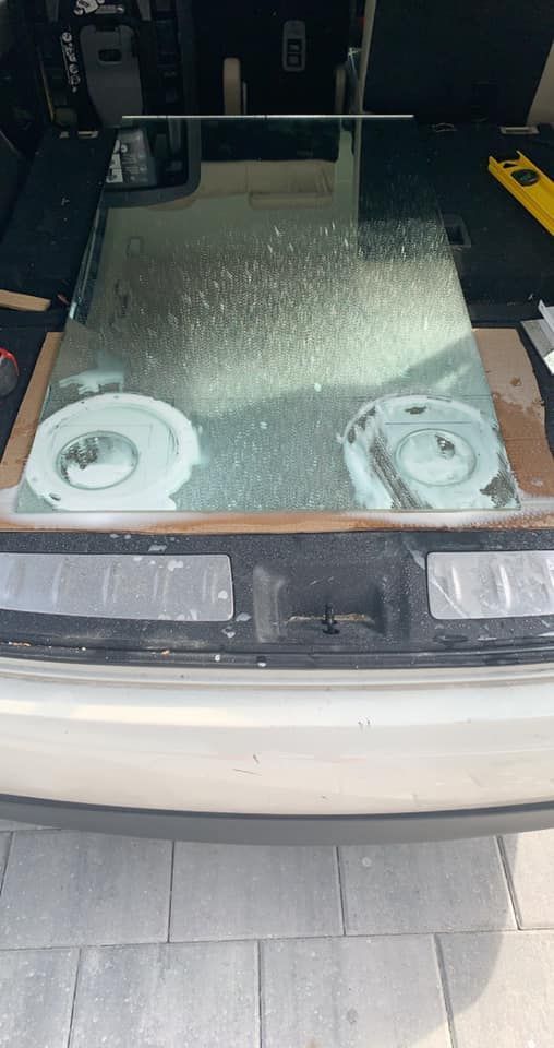 Glass panel with two circular objects, in the trunk of a car. Level visible.