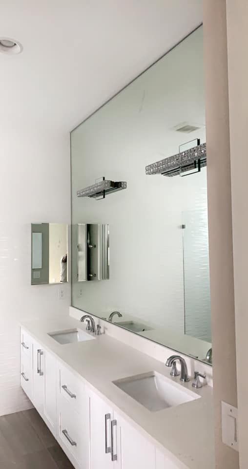 Modern bathroom with a large mirror over a double sink vanity.