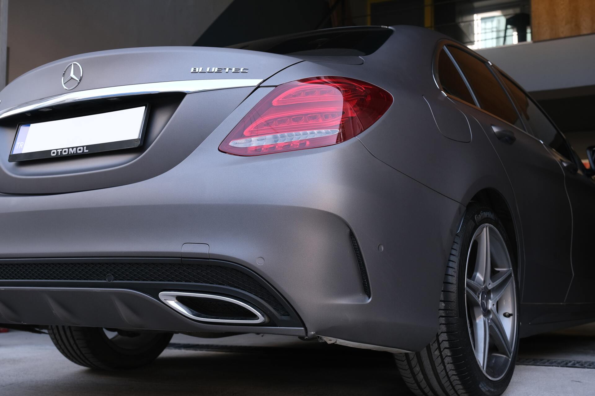 A person wearing black gloves is touching a tire