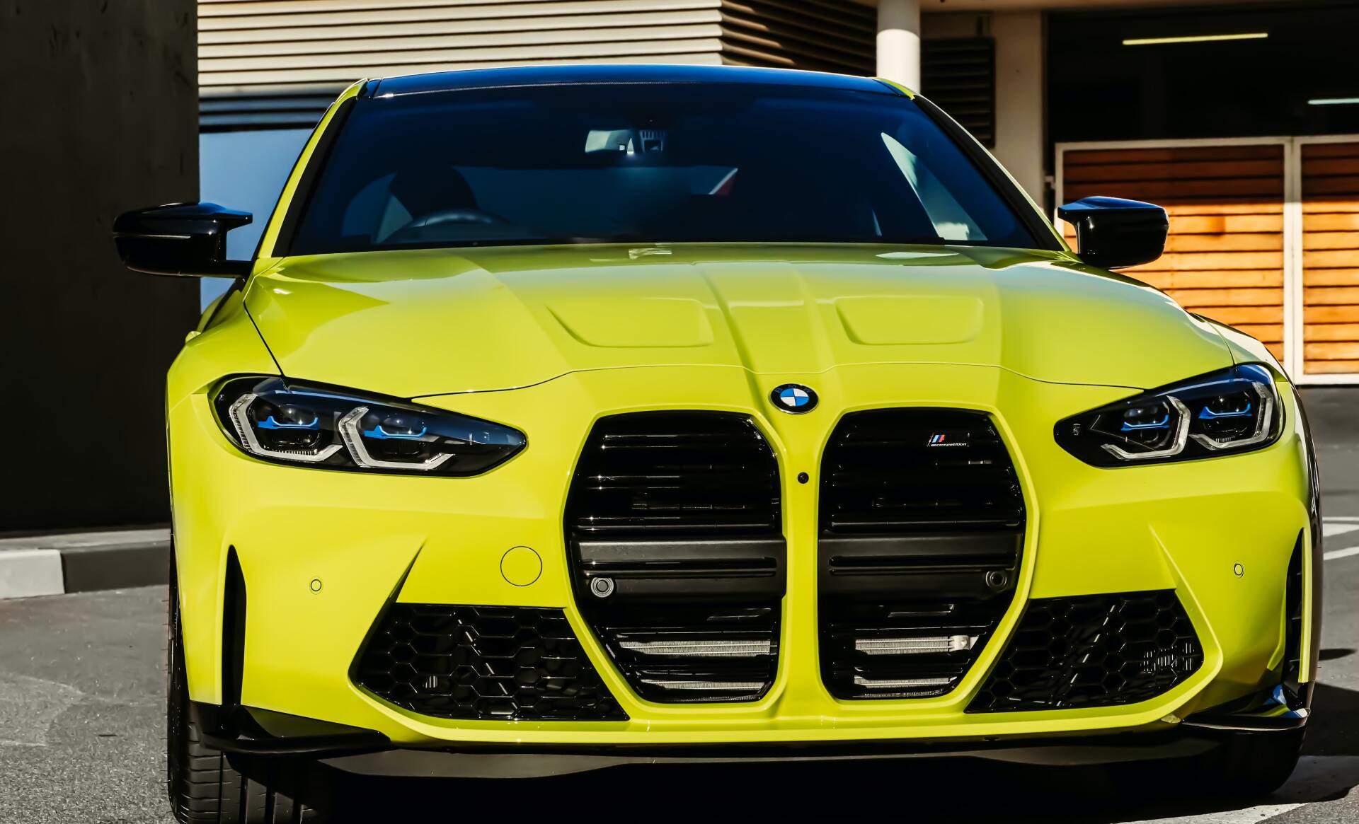 A yellow bmw m4 is parked in a parking lot.