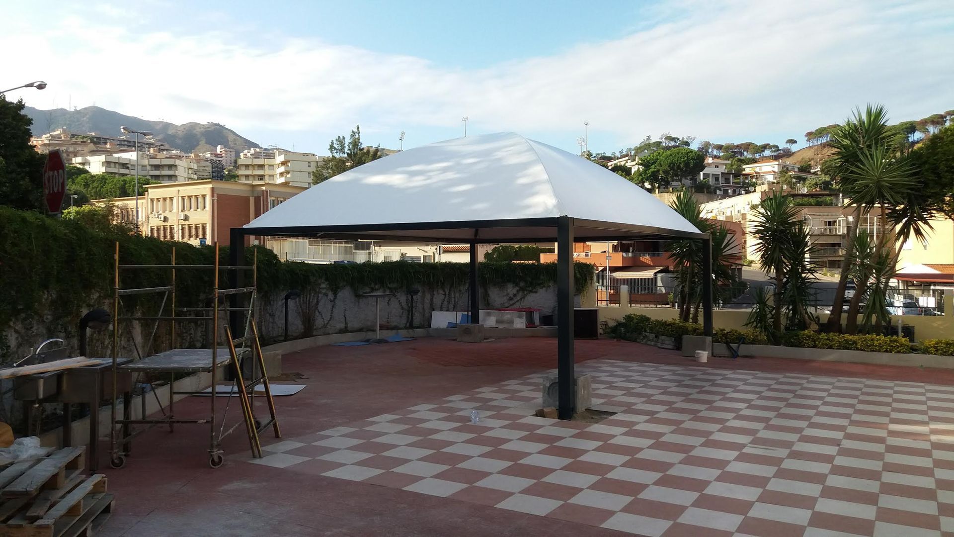 Una grande tenda bianca è posta sopra un pavimento a scacchi.