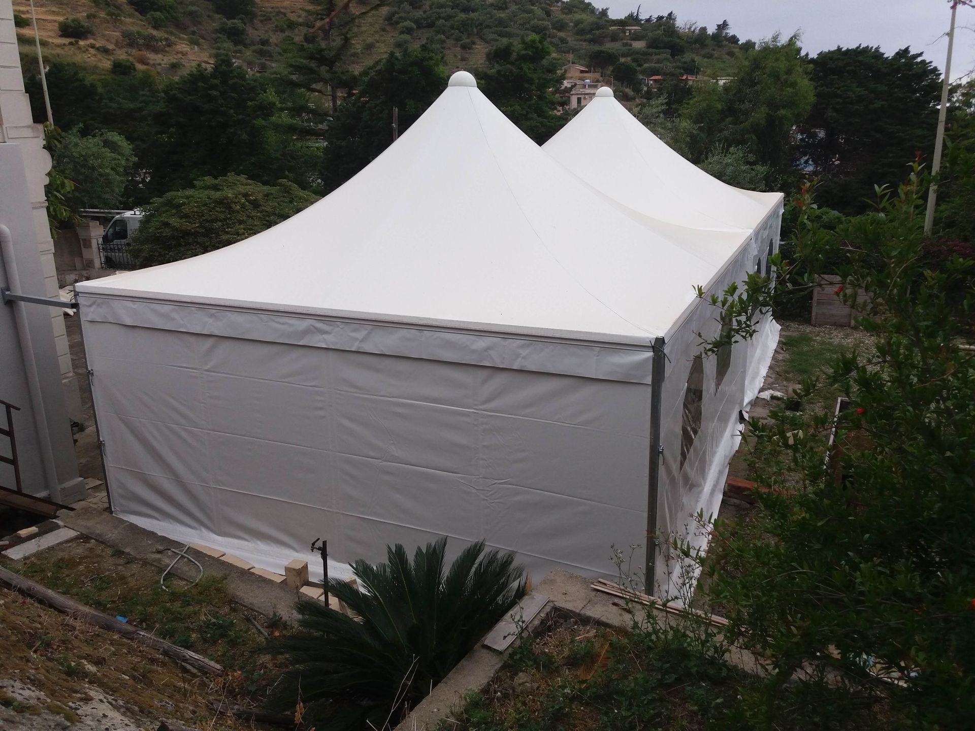 Una grande tenda bianca è seduta in cima a una collina