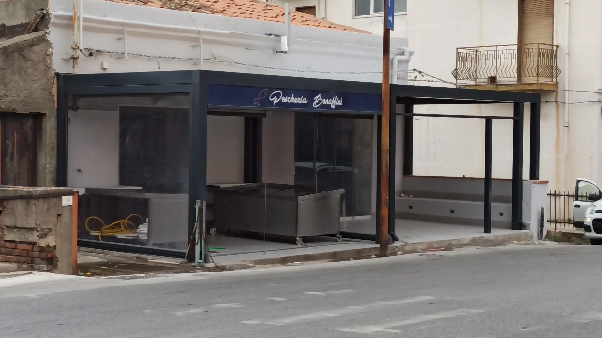 Un'auto bianca è parcheggiata davanti a un edificio.