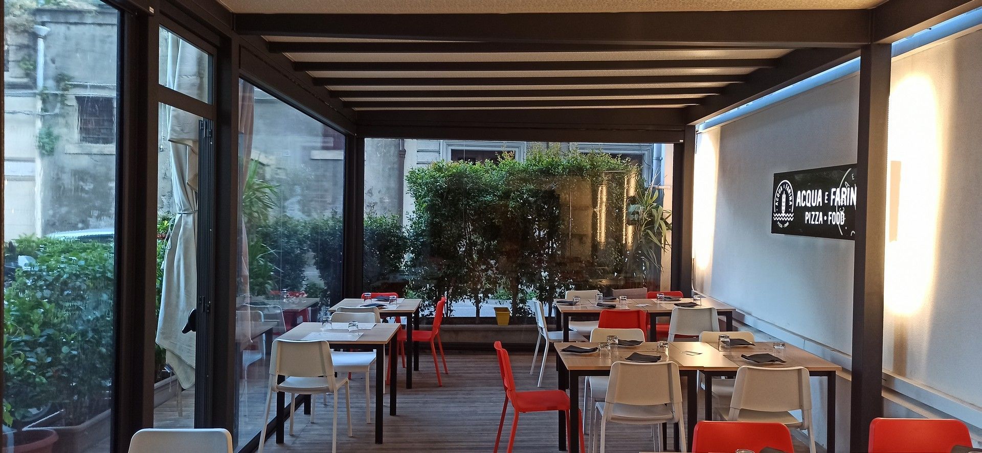 Un ristorante con tavoli e sedie e una televisione sul muro