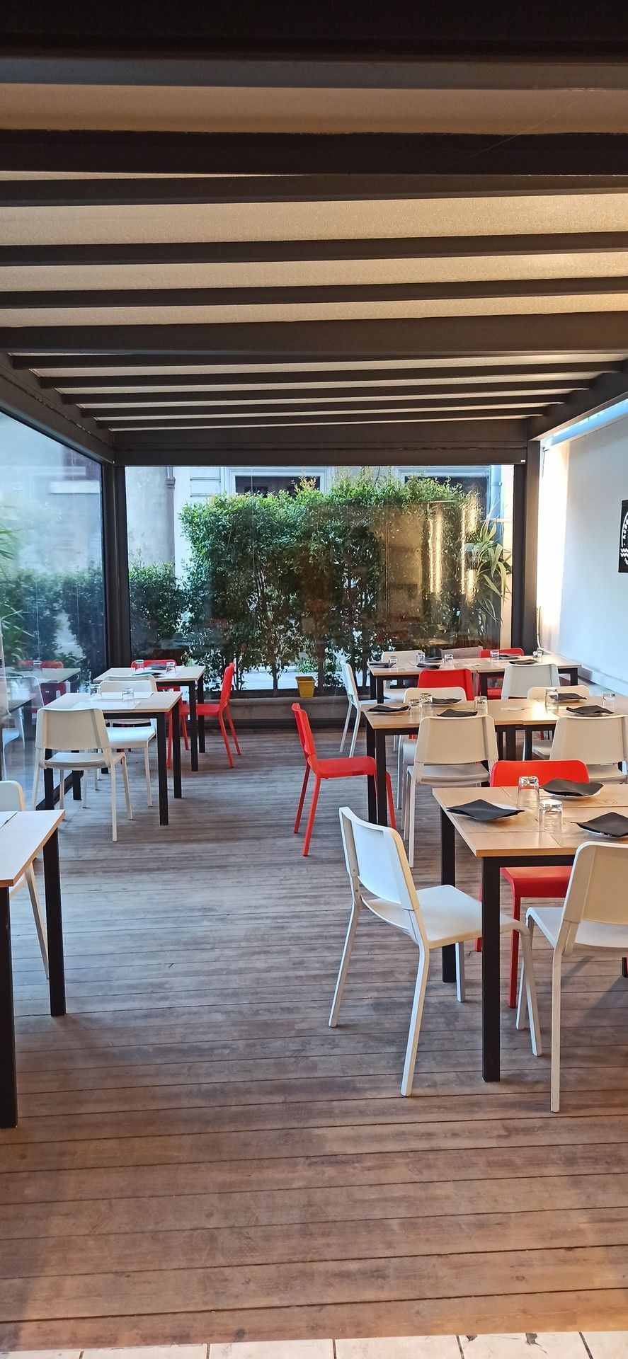 Un ristorante con tavoli e sedie sotto un pergolato.