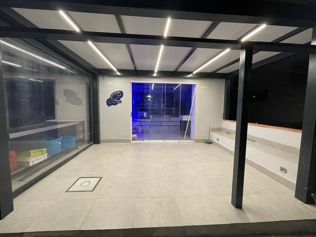 Una grande stanza vuota con una porta scorrevole in vetro che conduce in una stanza.