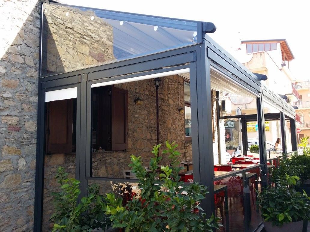 Un ristorante con tavoli e sedie sotto una tettoia