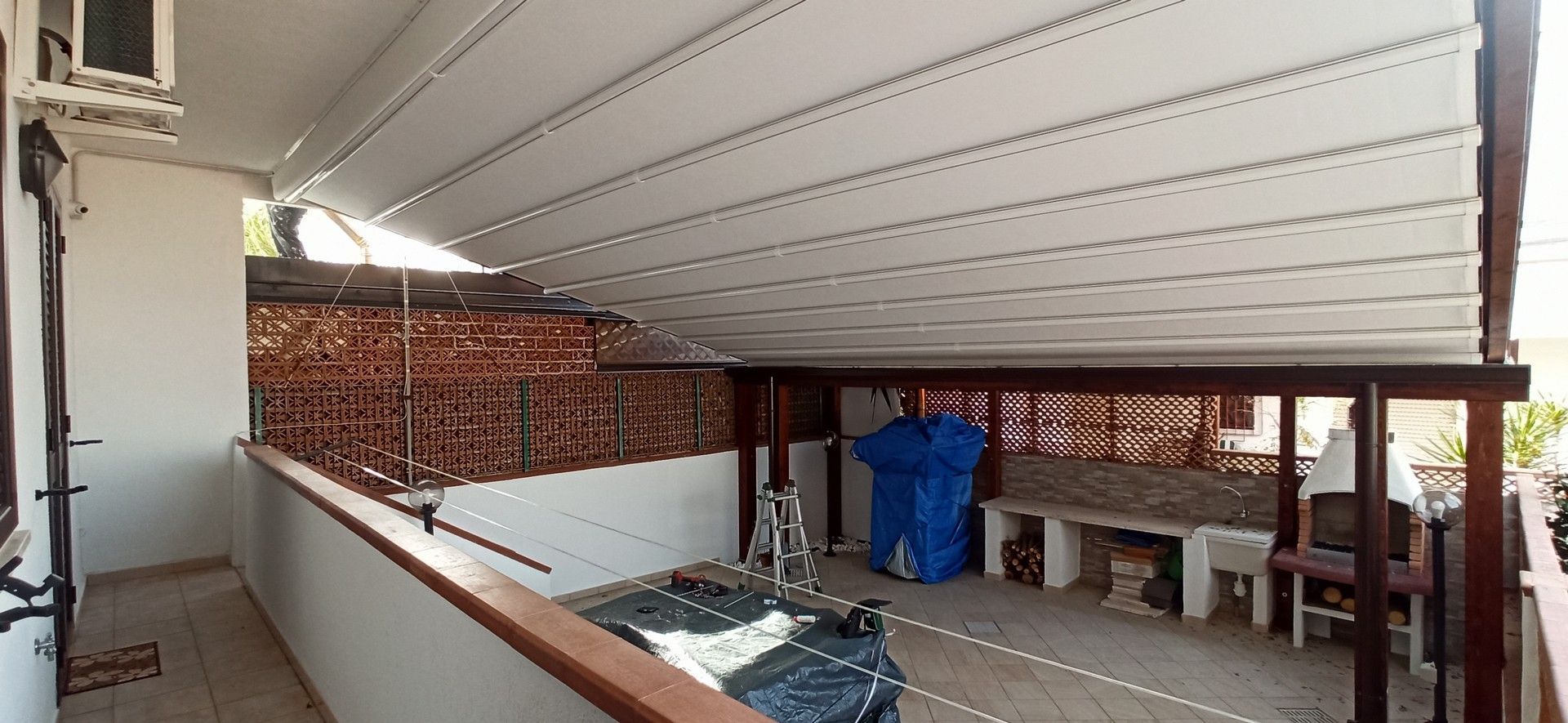 Un balcone con una tettoia sopra e un muro di mattoni dietro.