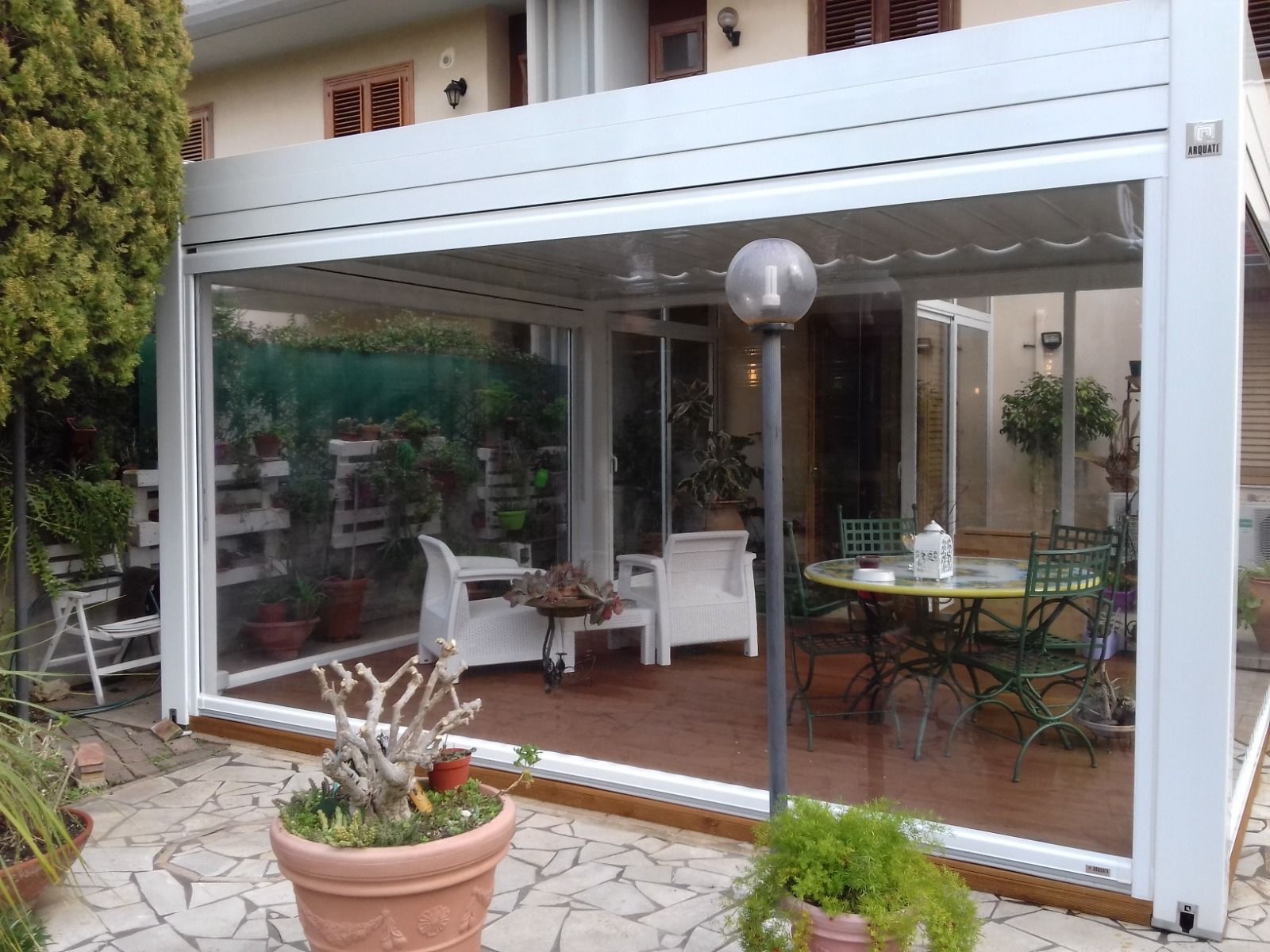 Un patio con tavolo e sedie sotto un pergolato