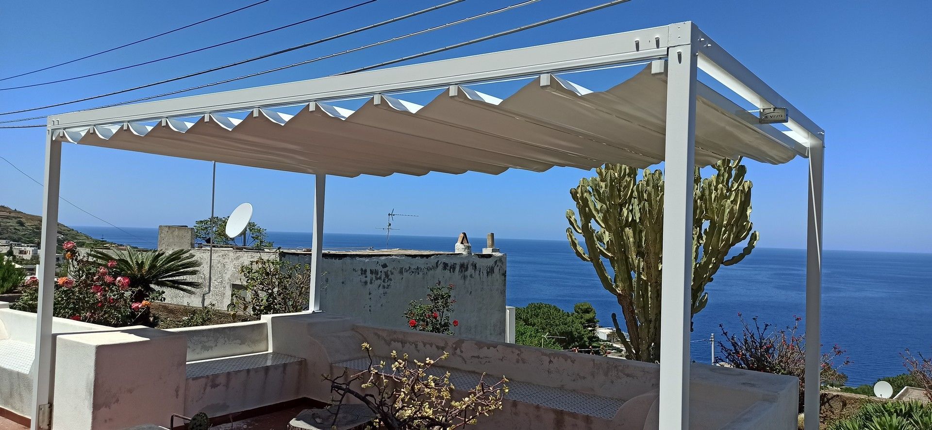Un baldacchino bianco è posto in cima a una scalinata che domina l'oceano.