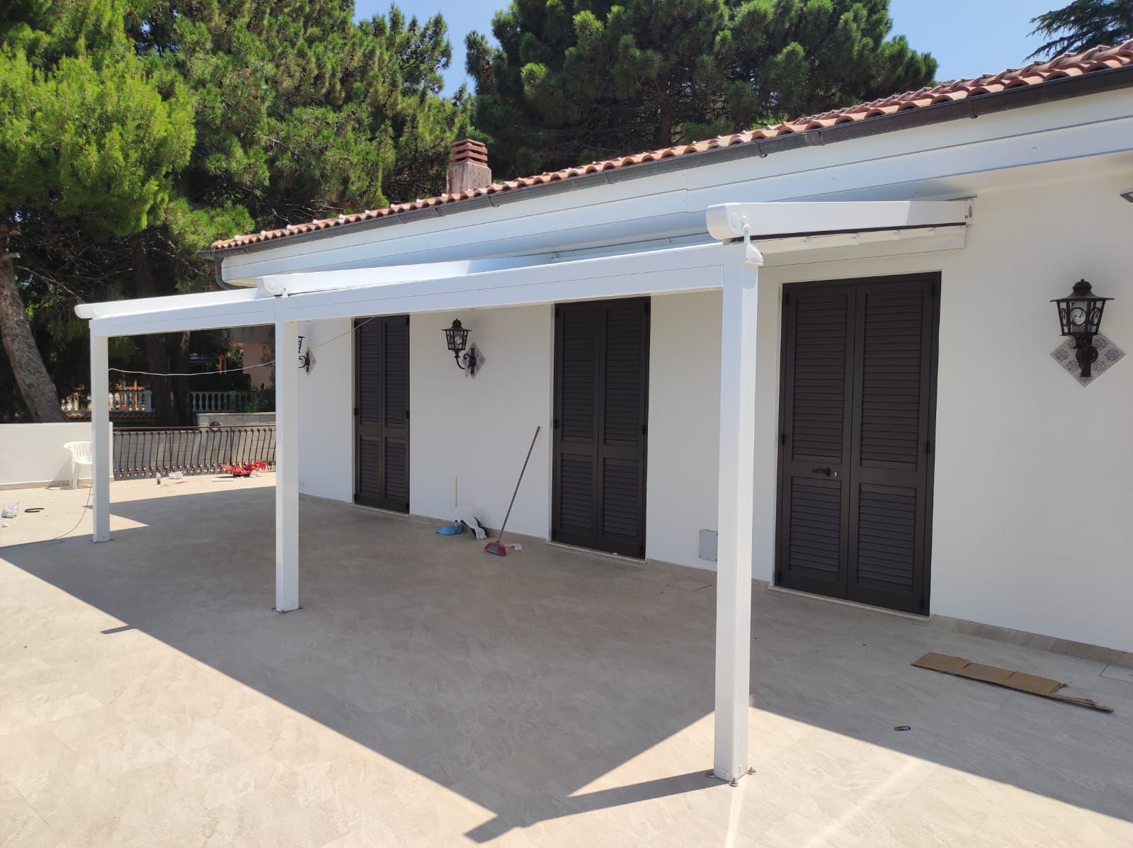 Una casa bianca con un pergolato bianco in cima