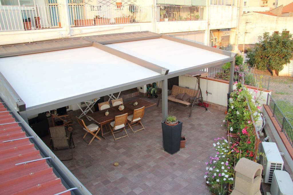 Un patio con tavolo e sedie sotto una tettoia