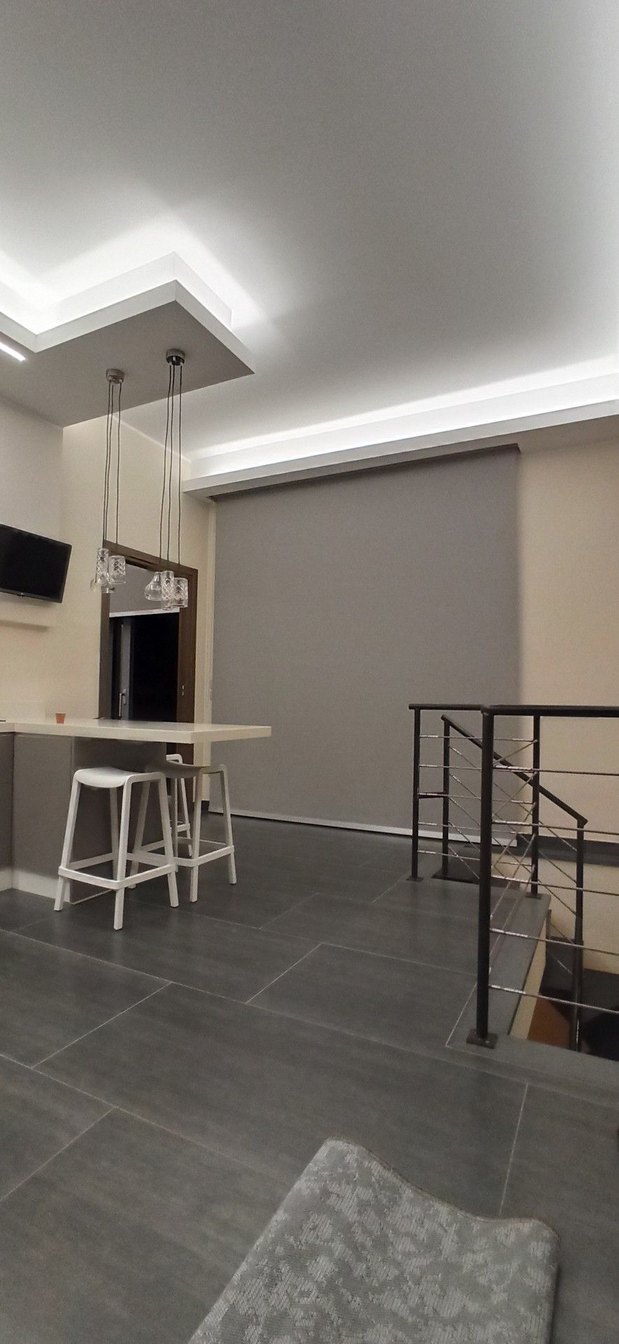 Un soggiorno con una scala e una cucina sullo sfondo.