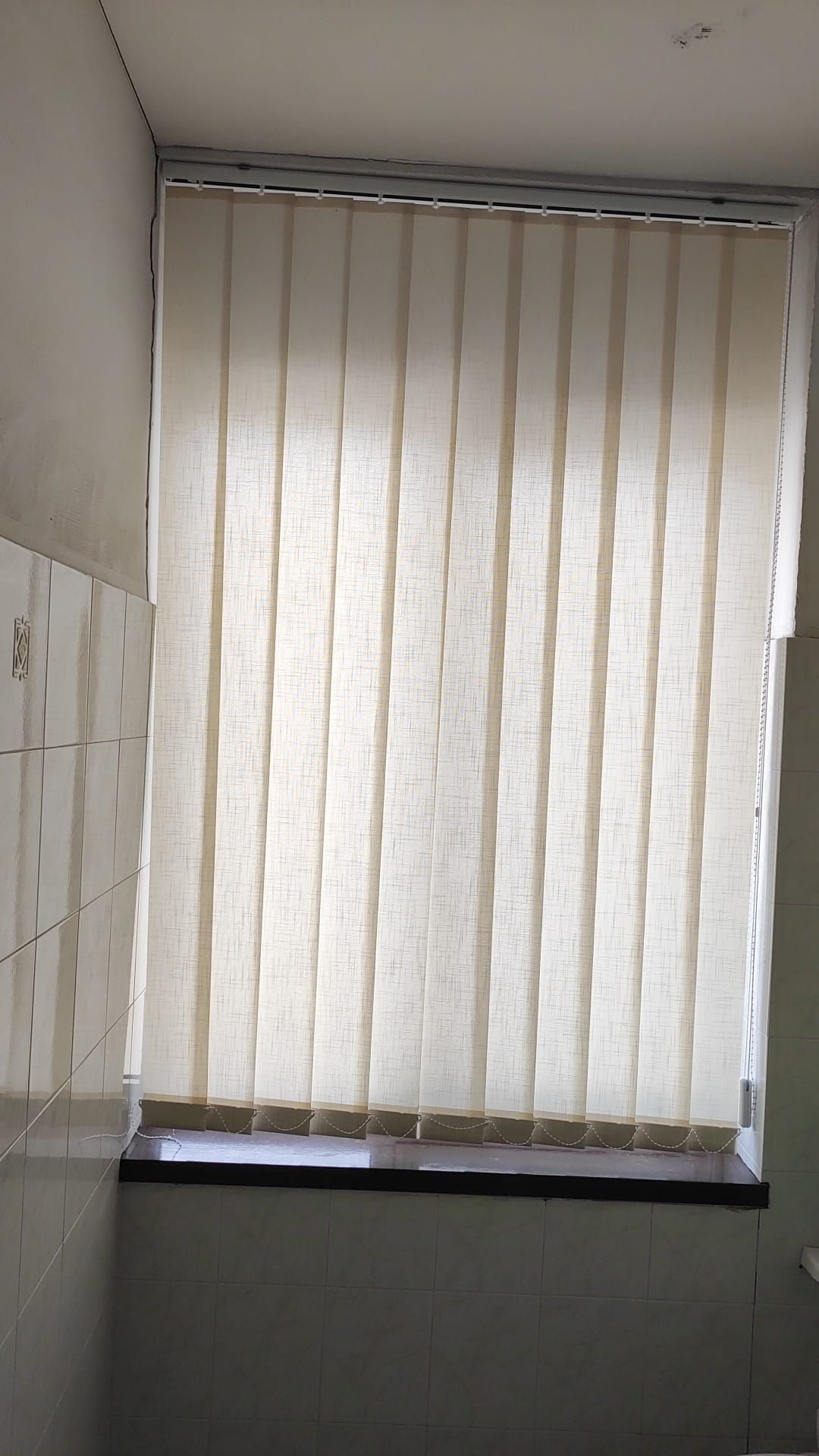 Una finestra con delle persiane verticali in un bagno.