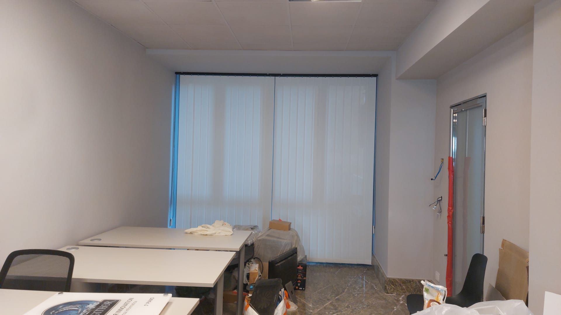 Una stanza con molti tavoli e sedie.