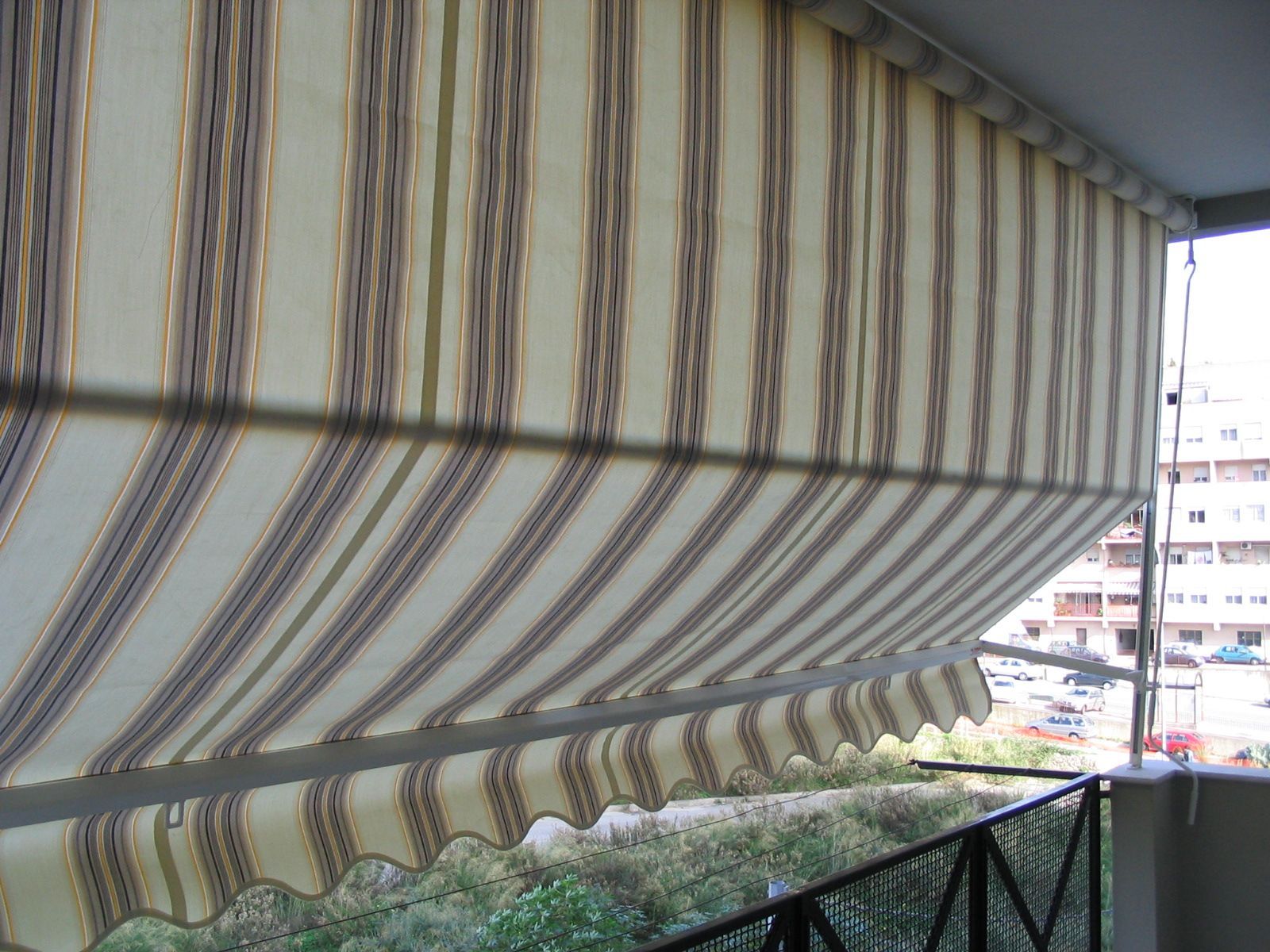 Un balcone con una tenda a strisce