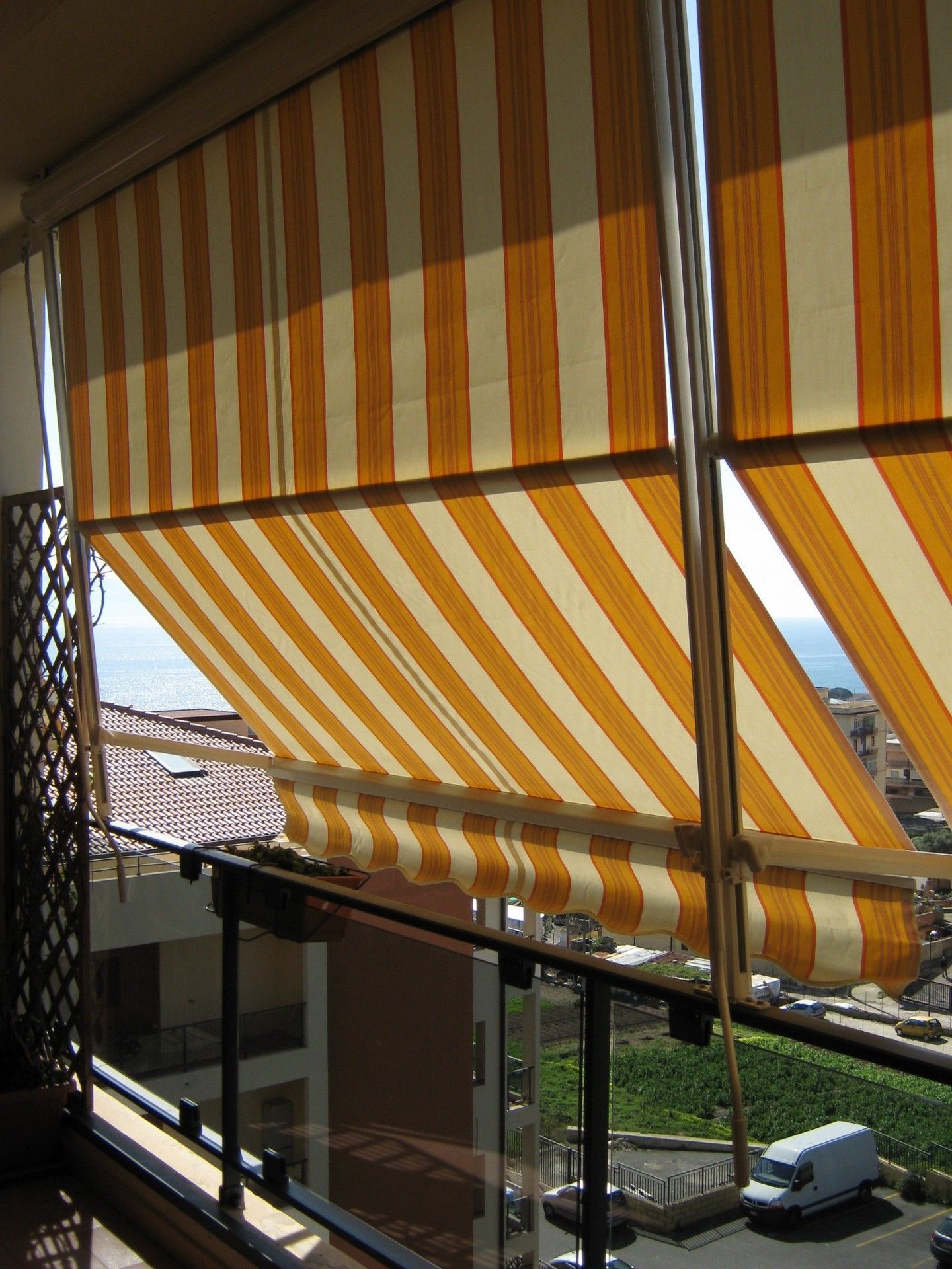 Un balcone con una tenda a strisce gialle e bianche