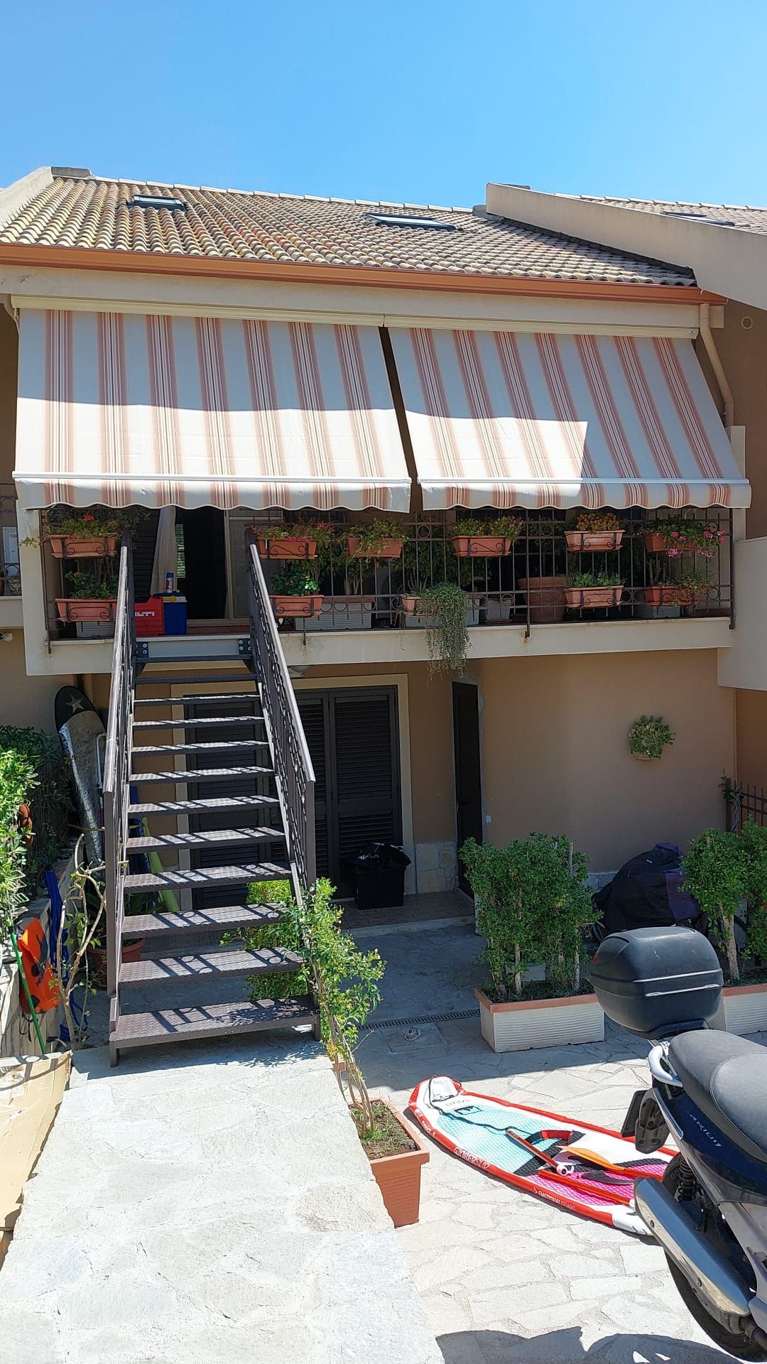 Una casa con scale e un kayak di fronte