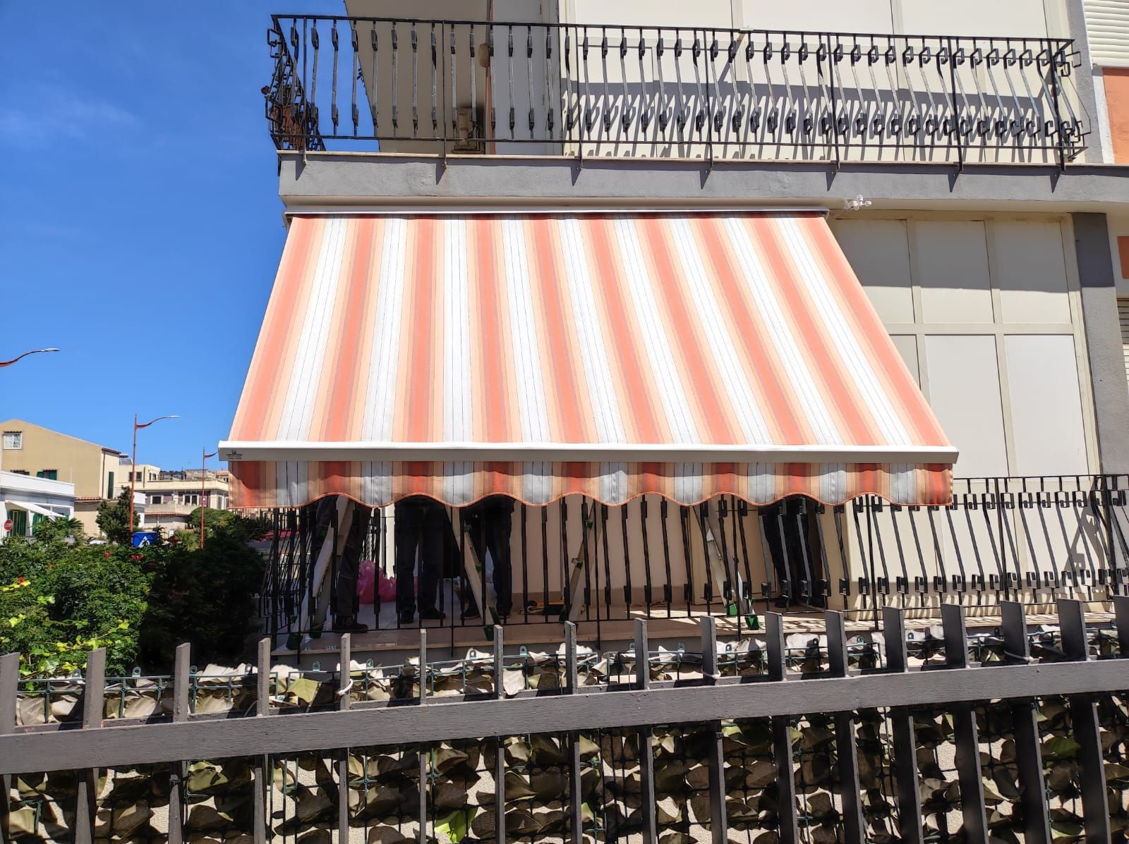 Un balcone con una tenda a strisce sopra