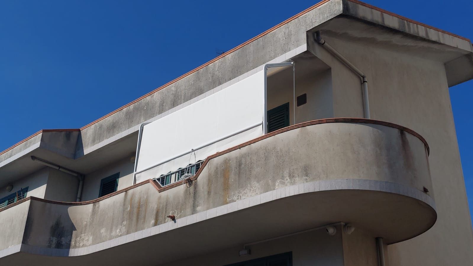Un edificio con un balcone e un cielo azzurro sullo sfondo