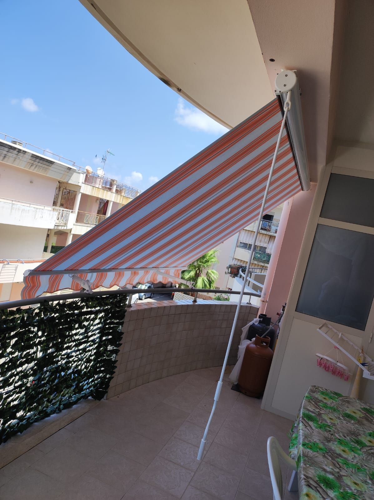 Un balcone con una tenda a strisce sopra