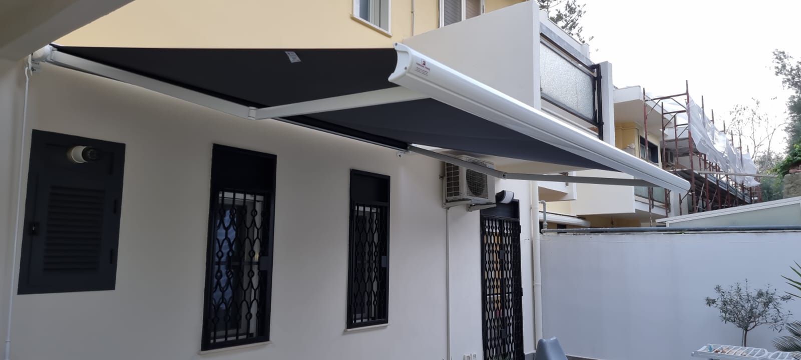 Un edificio bianco con una tenda nera su un lato.