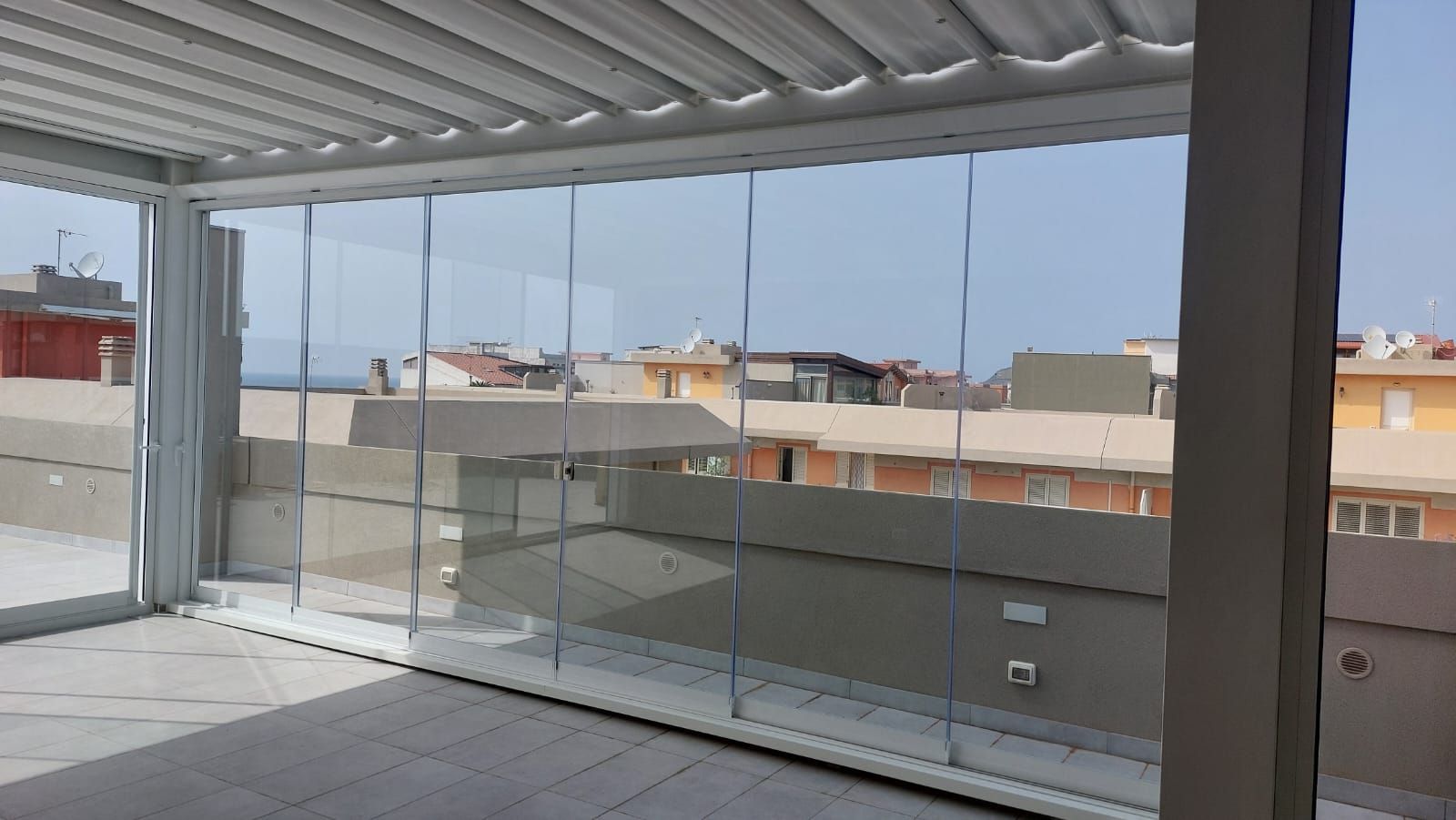 Una stanza con molte finestre e vista sulla città.