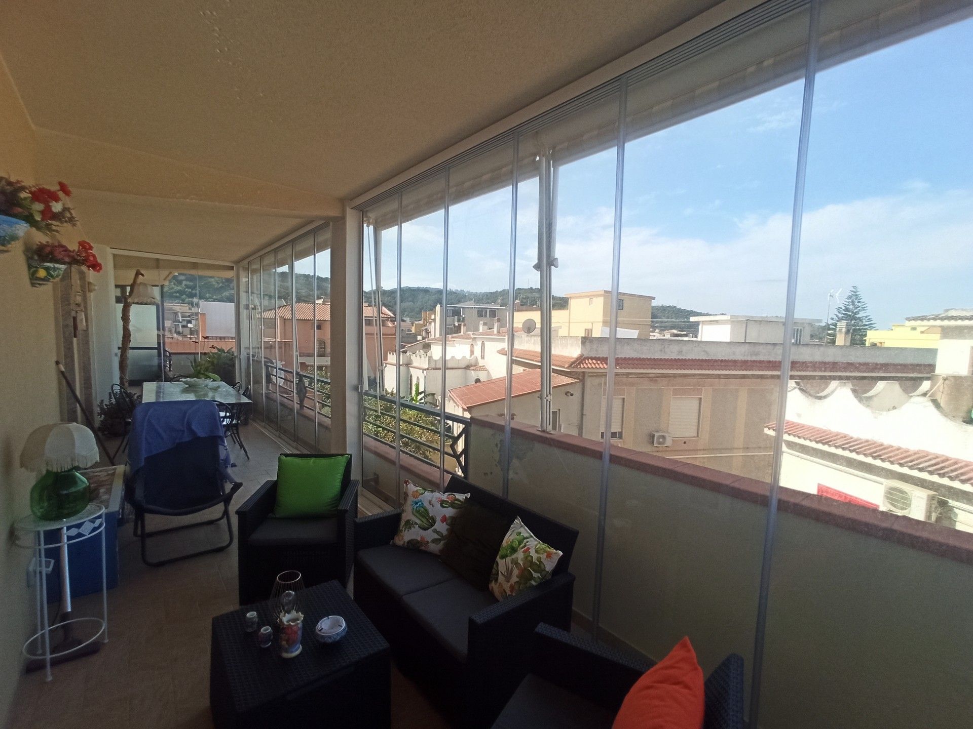 Un balcone con divano, sedie e tavolo