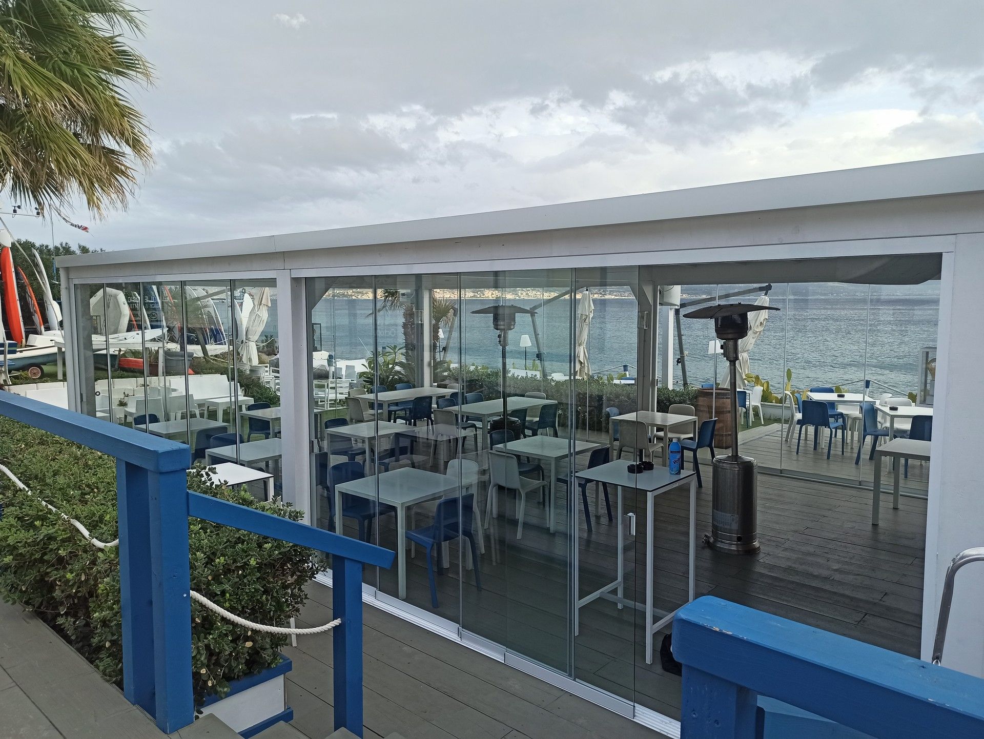 Un ristorante con tavoli e sedie e vista sull'oceano.