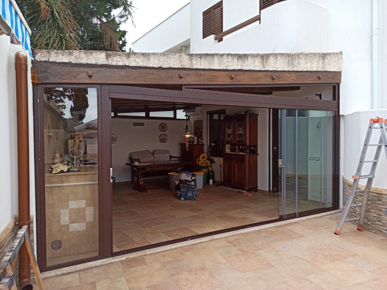 Un soggiorno con porte scorrevoli in vetro e una scala di fronte.