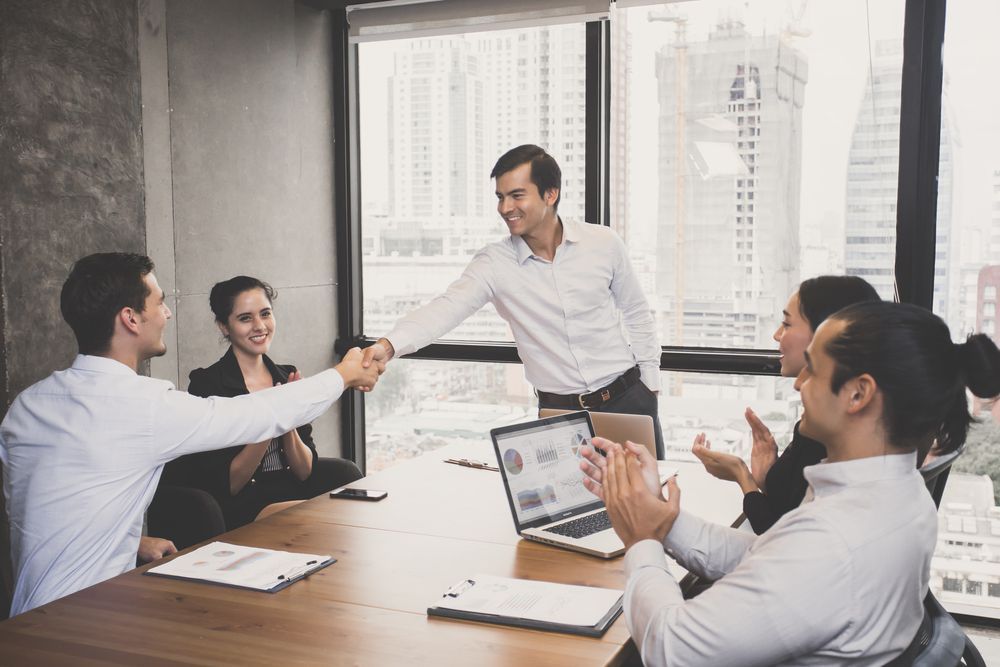 Professionals shaking hands in office symbolizing job growth and local economic development