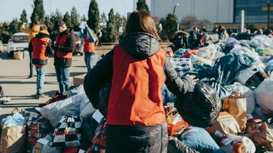 A group of people are standing around a pile of clothes.