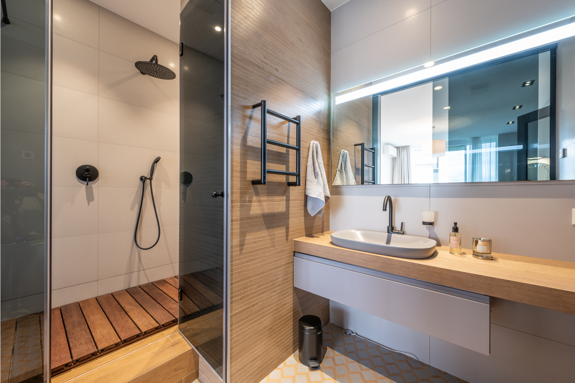 A bathroom with a sink , shower , and mirror.