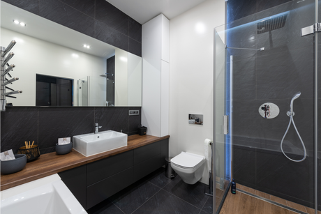 A bathroom with a sink , toilet , shower and mirror.