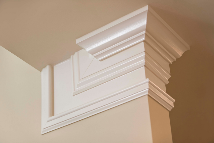 A close up of a white molding on the corner of a wall.