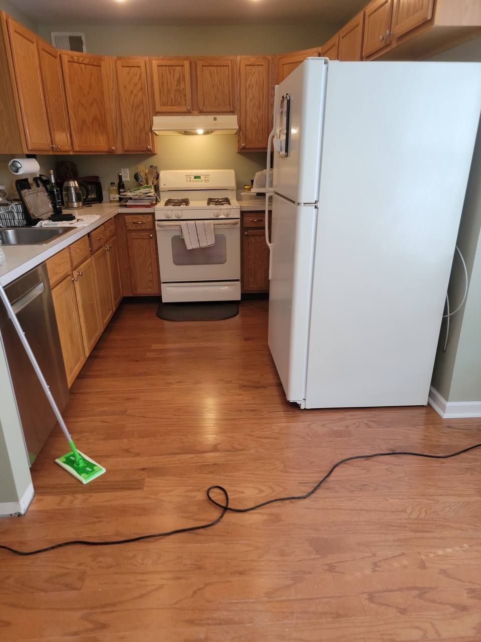 A kitchen with hardwood floors and a white refrigerator