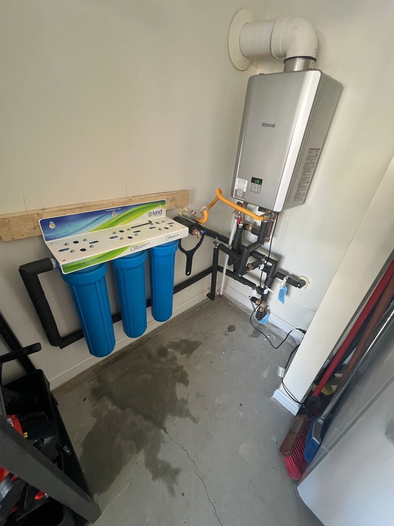 A room with a water heater and a water filter.