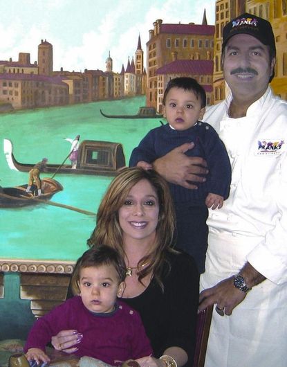 A family posing for a picture in front of a painting of venice