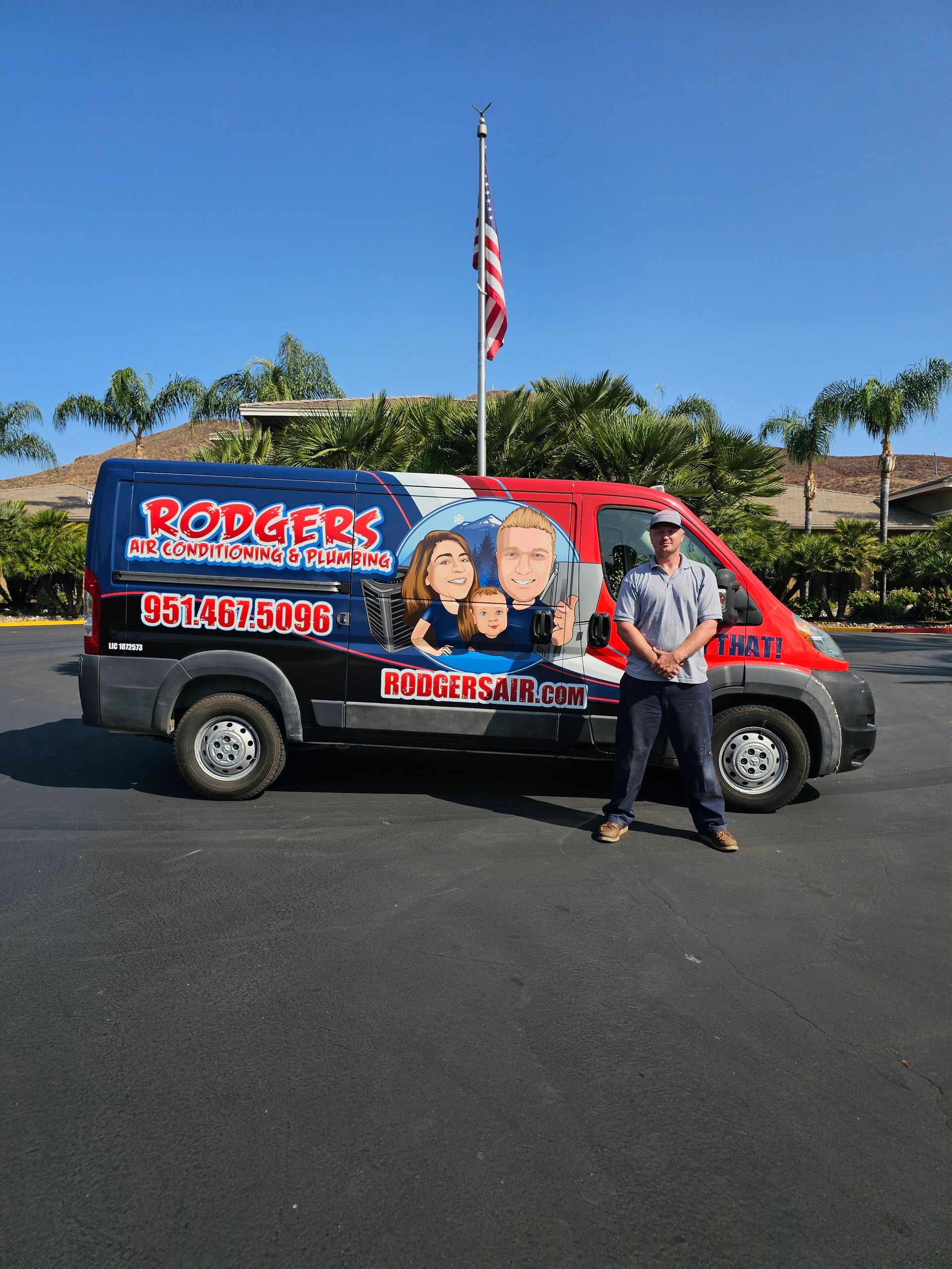 A man is standing in front of a red and blue van.