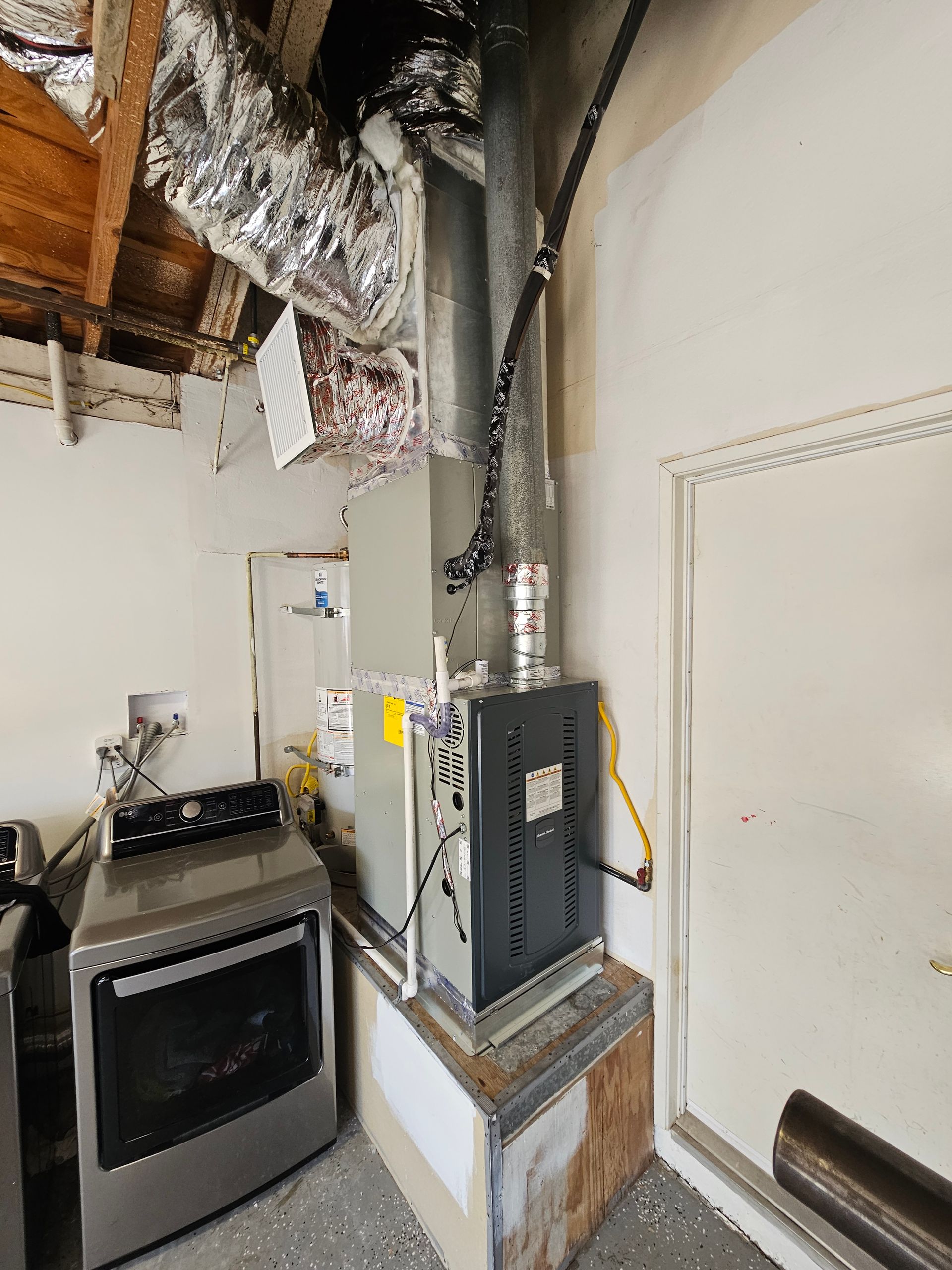 A kitchen with a stove and a furnace in the corner.