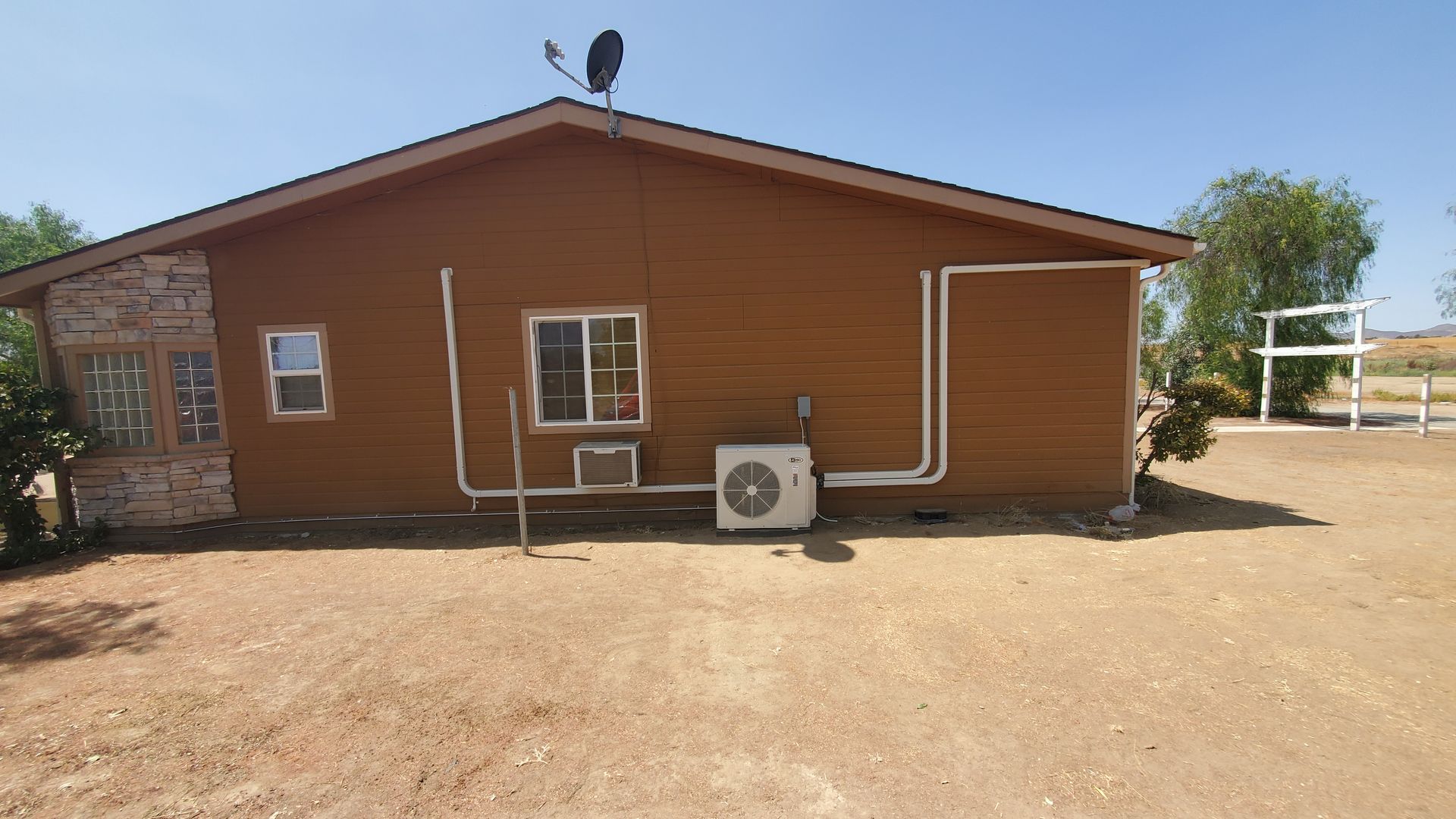 A brown house with a satellite dish on top of it