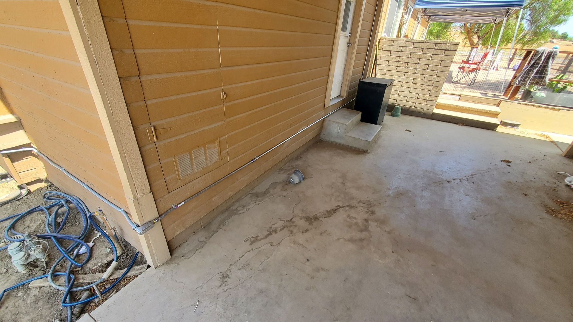 There is a hose on the ground in front of a house.