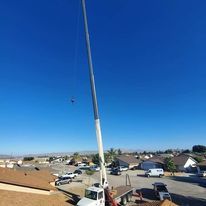A large crane is sitting on top of a truck in a residential area.