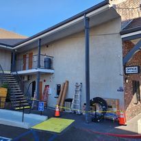 A large building with stairs leading up to it is being remodeled.