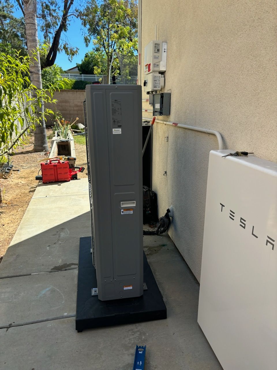 A tesla solar panel is sitting on the side of a building