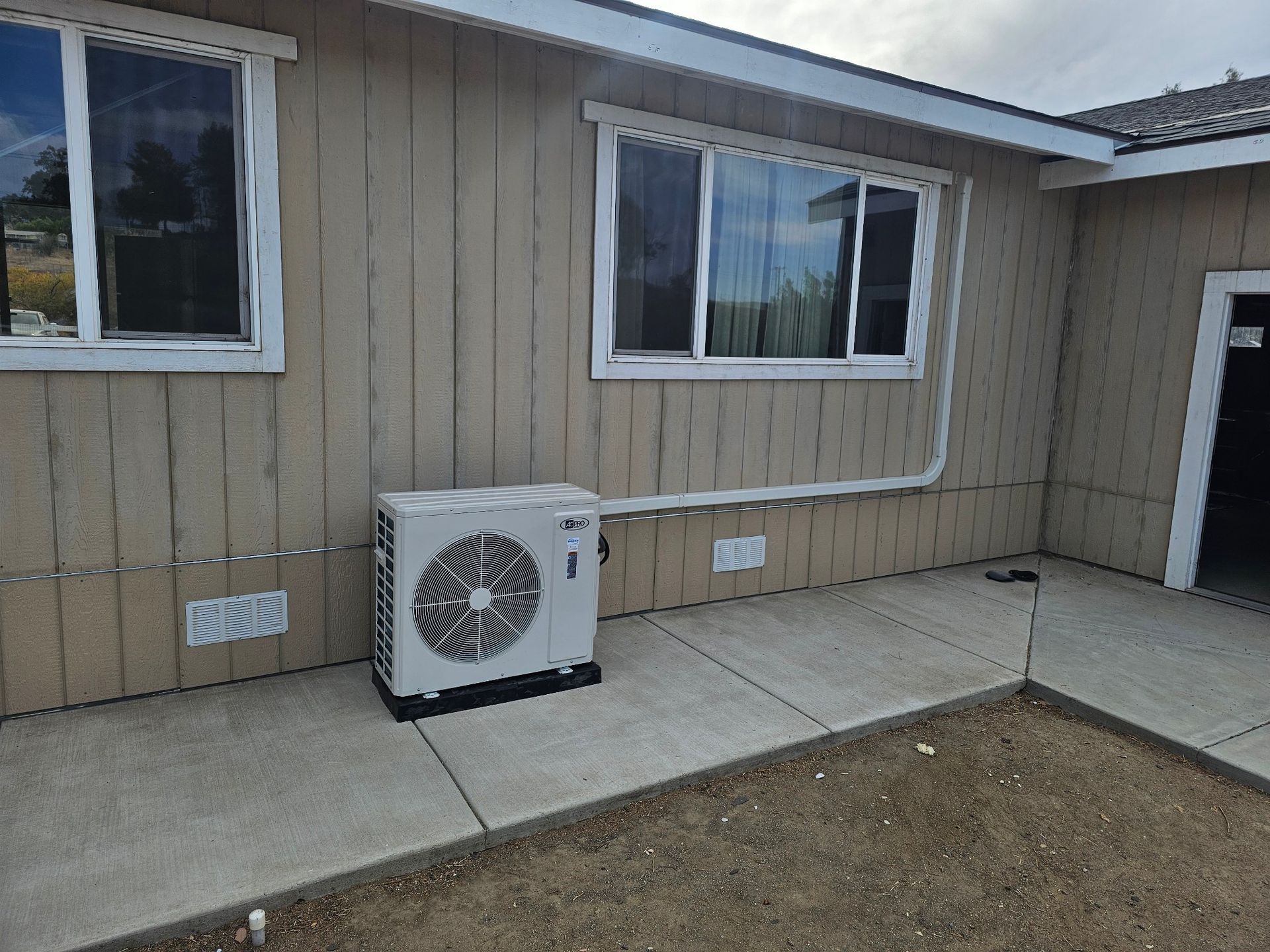 A house with a large air conditioner on the side of it.