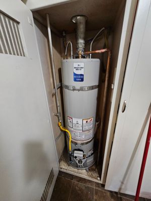 Two water heaters are sitting next to each other in a room.