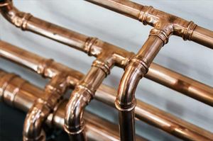 A close up of a bunch of copper pipes on a table.