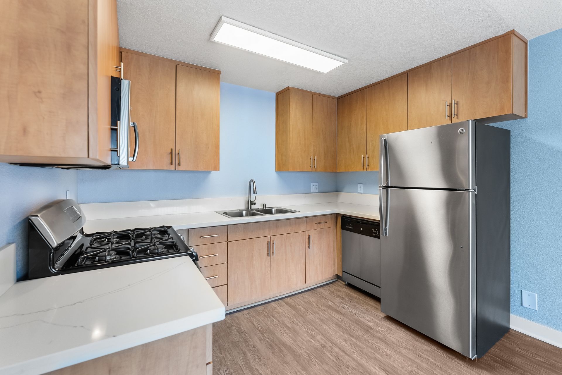 A kitchen with stainless steel appliances and wooden cabinets